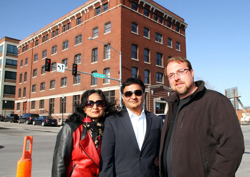 ADVANCE FOR WEEKEND EDITIONS APRIL 25-26 - In this April 22, 2015 photo, Manisha, left and Manoj Baheti, owners of Y & J Properties, with developer Joe Erenberger developed the Halligan Coffee Company Lofts into 45 market rate lofts that will be available for occupancy on May 1 in Davenport, Iowa. Y & J Properties celebrated the completion of its most recent project, the $6.5 million Halligan Coffee Co. Lofts. Business leaders, city officials and others attended a ribbon-cutting ceremony Wednesday, April 22, 2015. (Kevin E. Schmidt/The Quad City Times via AP) MANDATORY CREDIT