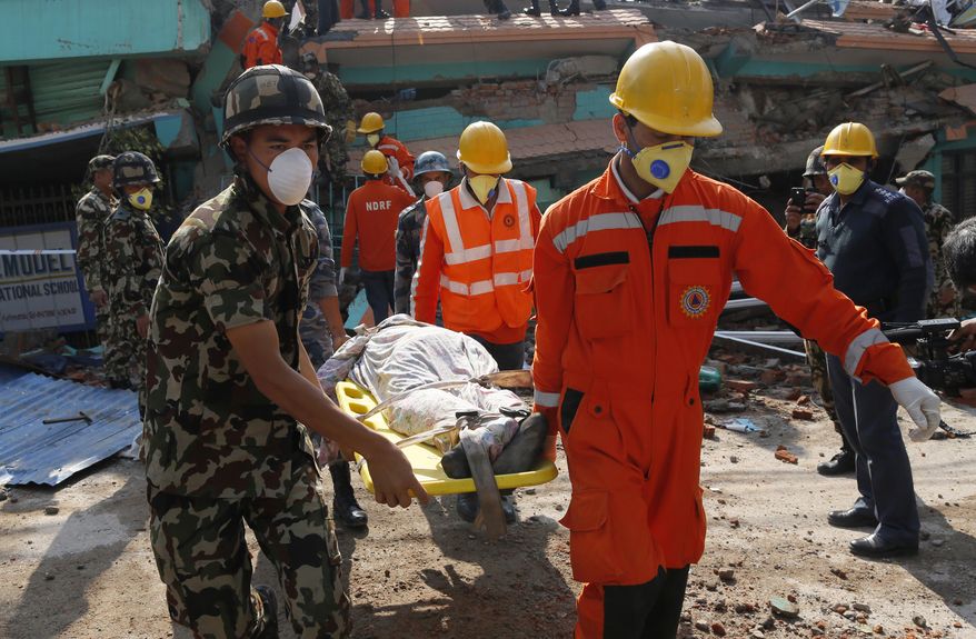 Rescue teams carry a body dug out of the collapsed Sitapyla church in Kathmandu, Nepal, Monday, April 27, 2015. A strong magnitude 7.8 earthquake shook Nepal&#x27;s capital and the densely populated Kathmandu Valley on Saturday, causing extensive damage with toppled walls and collapsed buildings. (AP Photo/Wally Santana)