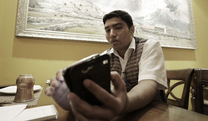 Bigyan Bhandari, a 28-year-old Nepalese who works at a Nepalese restaurant run by K.P. Sitoula, uses his smartphone to call his family members in Kathmandu during an interview in Seoul, South Korea Monday, April 27, 2015. Bhandari said he was finally able to talk with his loved ones in Kathmandu after dozens of unsuccessful attempts to call them. &amp;quot;I miss my family members ... too much,&amp;quot; he said, tears welling in his eyes. (AP Photo/Ahn Young-joon)