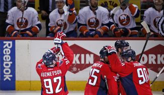 Washington Capitals center Evgeny Kuznetsov (92), from Russia, mimics a basketball shot in front of the New York Islanders bench after scoring the game winning goal during the third period of Game 7 in the first round of the NHL hockey Stanley Cup playoffs, Monday, April 27, 2015, in Washington. The Capitals won 2-1, to advance. (AP Photo/Alex Brandon)