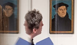 A visitor is reflected in a showcase besides the painting &#39;Bildnis Martin Luthers&#39; (1529) by Lucas Cranach the Elder during the press preview at the exhibition &#39;The Luther Portraits of the Cranach Workshop&#39; at the Wartburg castle in Eisenach, Germany, Tuesday, March 31, 2015. The exhibition, that also shows Luther portraits of contemporary artists, starts on April 2 and lasts until July 19, 2015. (AP Photo/Jens Meyer)