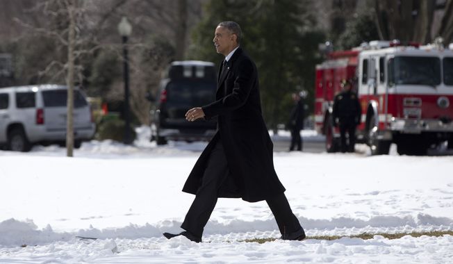 President Obama walks on a path across the snow covered South Lawn of the White House to board Marine One in Washington, for the short trip to Andrews Air Force Base, en route to Chicago, on Feb. 19, 2015. (Associated Press) **FILE**