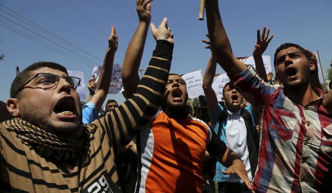 Palestinians chant slogans during a protest organized by the Palestinian Youth Organization, calling for an end to political division, reopening of the Rafah crossing border and the reconstruction of destroyed houses that were damaged in last summer&#x27;s Israel-Hamas war, in Gaza City , in the northern Gaza Strip, Wednesday, April 29, 2015. (AP Photo/Adel Hana)