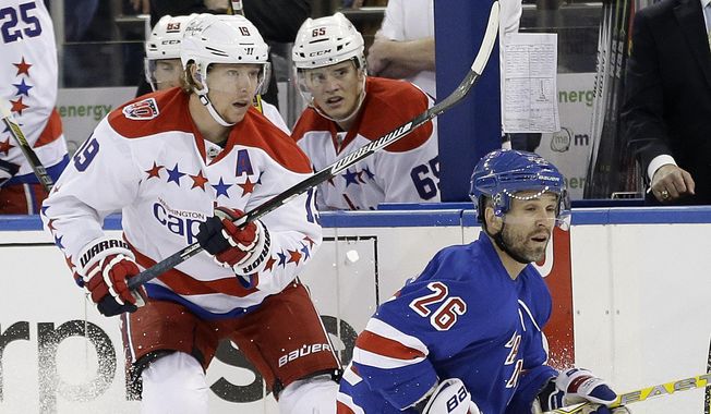 Washington Capitals center Nicklas Backstrom (19) and New York Rangers right wing Martin St. Louis (26) look down ice after a pass during the first period of Game 1 in the second round of the NHL Stanley Cup hockey playoffs, Thursday, April 30, 2015, in New York. (AP Photo/Frank Franklin II)