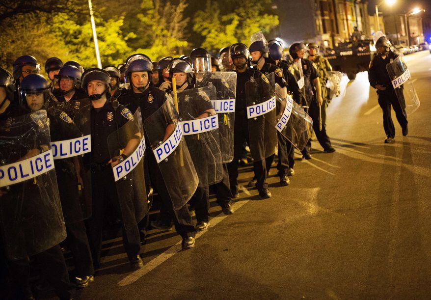 Police in riot gear line up near the scene of riots ahead of a 10 p.m. curfew Wednesday, April 29, 2015, in Baltimore. The curfew was imposed after unrest in Baltimore over the death of Freddie Gray while in police custody. (AP Photo/David Goldman)