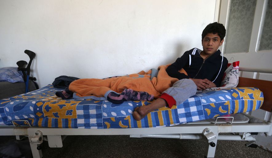 In this picture taken on Friday, April 17, 2015, 16-year-old Anas Baroudi shows his missing left foot, lost almost three years ago in the civil war in Syria, on his bed at the Dar Al-Salameh center for recovery and physiotherapy, in Kilis town near the Syrian border in Turkey. (AP Photo/Hussein Malla)