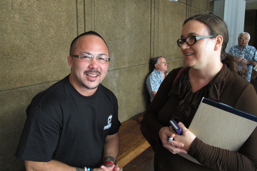 Kaleo Ramos, left, and Rebecca Copeland, right, react outside a legislative hearing room on Thursday, April 30, 2015, in Honolulu. A key committee had just passed a bill that would enable transgender people to change gender on their birth certificates without having to undergo gender reassignment surgery. (AP Photo/Cathy Bussewitz)