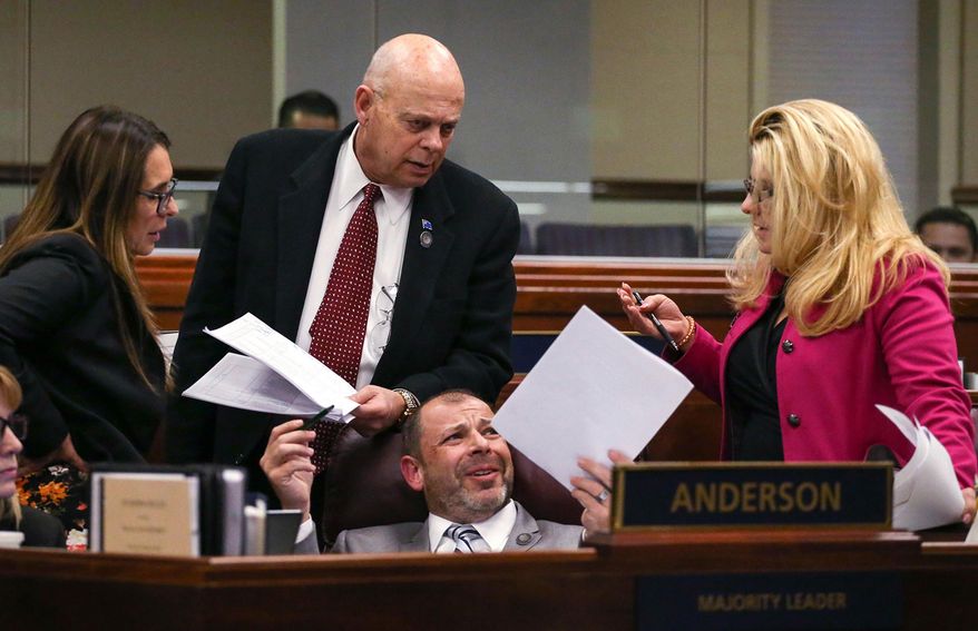 FILE - In this April 21, 2015 file photo , Nevada Assembly Republicans, standing from left, Victoria Seaman, Jim Wheeler and Michele Fiore talk with Assembly Majority Leader Paul Anderson, center, on the Assembly floor at the Legislative Building in Carson City, Nev. While acknowledging the difficulties in working with the 24 other Republicans in his caucus, Anderson says he’s extremely confident that the group will be able to work together and find a way to fund Gov. Brian Sandoval’s budget with little less than a month to go in the session. (AP Photo/Cathleen Allison, File)