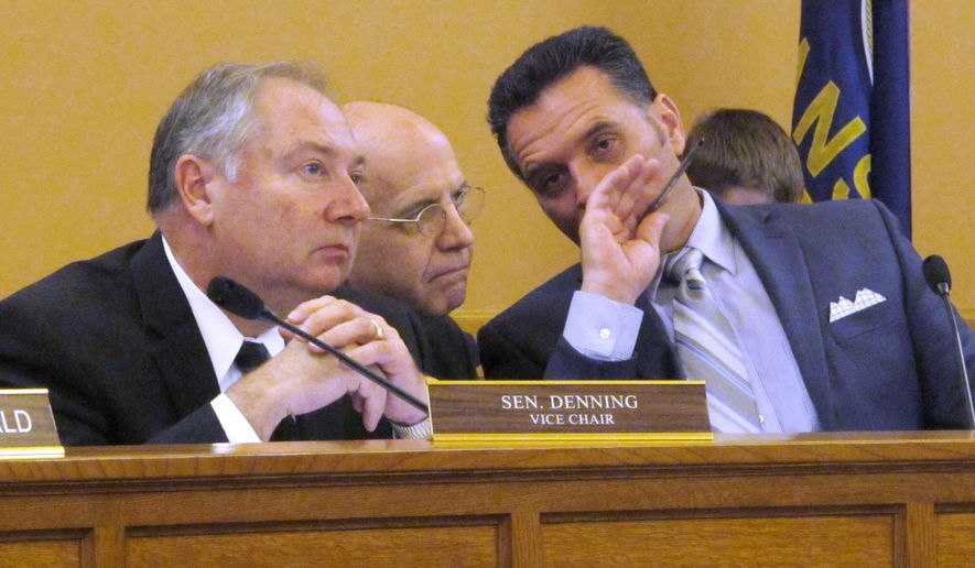 FILE - In this April 28, 2015 file photo, J.G. Scott, center, the chief fiscal analyst for the Kansas Legislative Research Department, confers with Republican state Sens. Jim Denning, left, of Overland Park, and Ty Masterson, right, of Andover, during a committee briefing on budget issues at the Statehouse in Topeka, Kan. Denning wants legislators to balance the budget by narrowing an income tax exemption for business owners enacted in 2012. (AP Photo/John Hanna, File)
