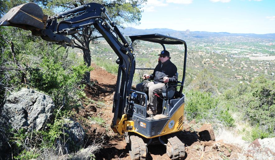 In this April 29, 2015 photo, City of Prescott's Trails and Natural Parklands coordinator Chris Hosking works on a section of the Circle Trail called the Badger Mountain Trail overlooking Prescott, Ariz. Work is progressing this month to finally close the gap in the Prescott Circle Trail that would allow hikers more views of the city. (Les Stukenberg/The Daily Courier via AP) MANDATORY CREDIT