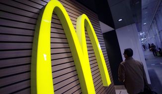 A man walks by a McDonald&#39;s logo in front of its restaurant in Tokyo in this Dec. 17, 2014, file photo. McDonald’s is set to unveil its latest plans to revive its sputtering business on Monday, May 4, 2015. (AP Photo/Eugene Hoshiko, File)