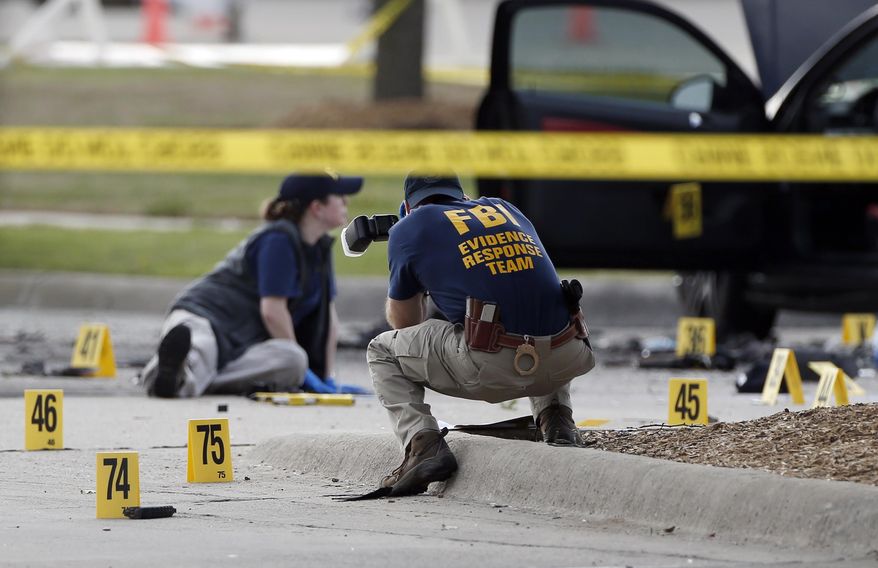 FBI crime scene investigators document the area around two deceased gunmen and their vehicle outside the Curtis Culwell Center in Garland, Texas, Monday, May 4, 2015. Police shot and killed the men after they opened fire on a security officer outside the suburban Dallas venue, which was hosting provocative contest for Prophet Muhammad cartoons Sunday night, authorities said. (AP Photo/Brandon Wade)