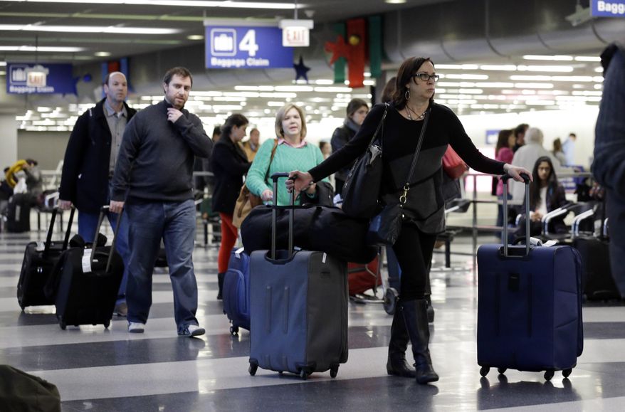 FILE - In this Dec. 1, 2013 file photo, travelers walk through terminal 3 baggage claim at O'Hare International airport in Chicago. The Department of Transportation on Monday, May 4, 2015 said that airline net income fell to $7.5 billion in 2014 from $12.2 billion in 2013. Airlines collected $3.5 billion in bag fees, a 5 percent increase over 2013. (AP Photo/Nam Y. Huh, File)