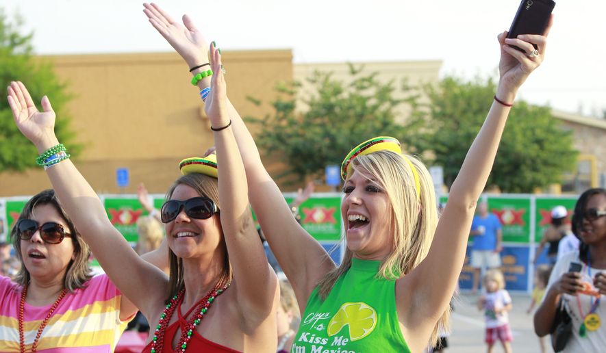 Sara Macalik (left) and Whitney Beauford dance to La Freak at On The Border&#39;s Cinco de Mayo Party in Addison, Texas. (Associated Press)