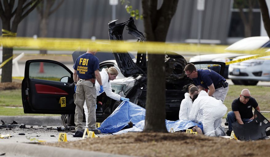 FBI crime scene investigators document the area around two deceased gunmen and their vehicle outside the Curtis Culwell Center in Garland, Texas, Monday, May 4, 2015. Police shot and killed the men after they opened fire on a security officer outside the suburban Dallas venue, which was hosting provocative contest for Prophet Muhammad cartoons Sunday night. (AP Photo/Brandon Wade)