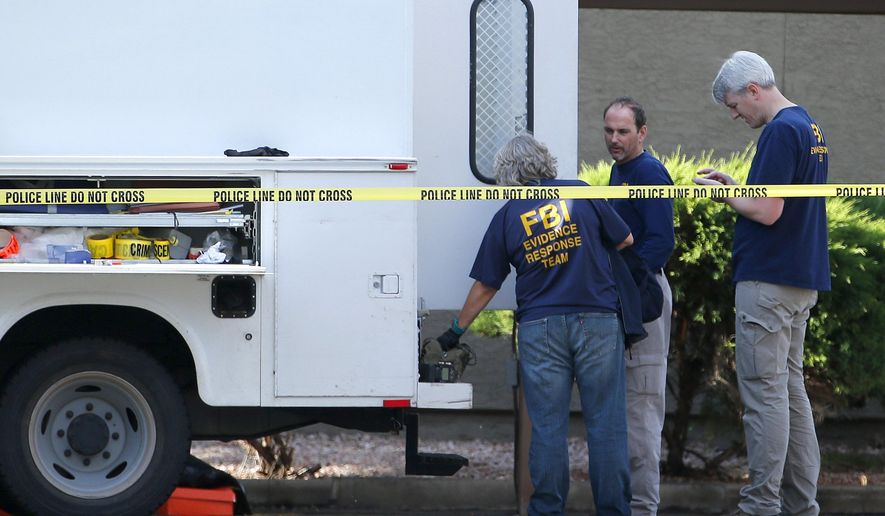 FBI investigators stand near an apartment being searched Monday, May 4, 2015, in Phoenix, believed to be the home of one of two gunmen who were shot and killed the night before outside a venue hosting an exhibit about the Prophet Muhammad in suburban Dallas. Garland, Texas, police officer Joe Harn says the men had opened fire with assault rifles, and that one officer had fatally shot both gunmen. (AP Photo/Ross D. Franklin)
