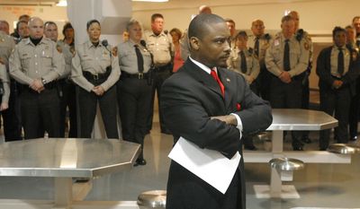 In this Thursday, Jan. 13, 2005, file photo, newly sworn-in Clayton County Sheriff Victor Hill, foreground, stands with arms folded after speaking to his deputies in Jonesboro, Ga. (Zach Porter/Clayton Daily News, File via AP)