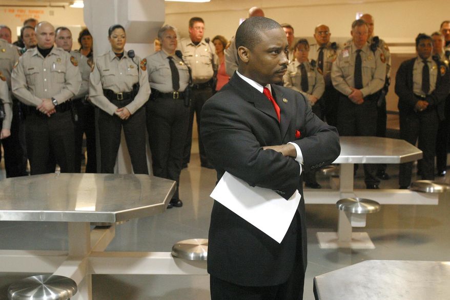 In this Thursday, Jan. 13, 2005, file photo, newly sworn-in Clayton County Sheriff Victor Hill, foreground, stands with arms folded after speaking to his deputies in Jonesboro, Ga. (Zach Porter/Clayton Daily News, File via AP)