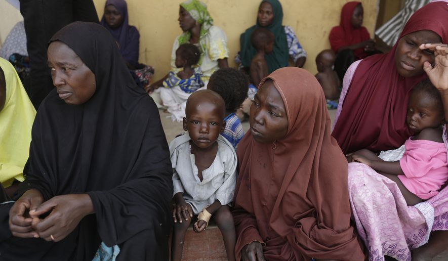 Women and children rescued by Nigerian soldiers from Boko Haram extremists at Sambisa Forest wait for treatment at at a refugee camp in Yola, Nigeria Monday, May 4, 2015. Even with the crackle of gunfire signaling rescuers were near, the horrors did not end: Boko Haram fighters stoned captives to death, some girls and women were crushed by an armored car and three died when a land mine exploded as they walked to freedom.  (AP Photo/Sunday Alamba)