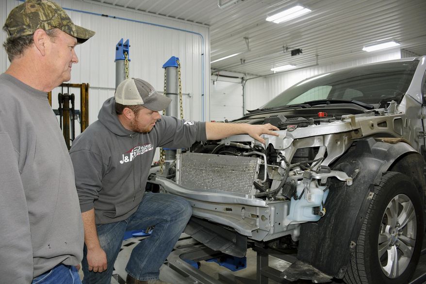 In this March 27, 2015 photo, Roger Buhnerkempe, left, and his son, Jake, check out a vehicle being repaired at their shop in Effingham, Ill. It's only been six months since the father and son opened J&R Collision on the south side of Effingham and already Jake is looking to grow the business as demand increases. (Cathy Griffith/Effingham Daily News via AP)