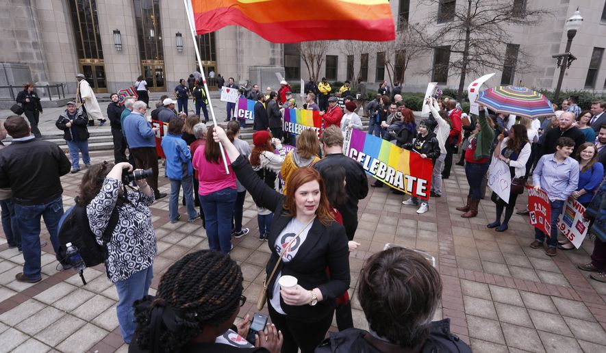 Amanda Keller holds a flag as she joins other gay marriage supporters in Linn Park at the Jefferson County courthouse Feb. 9 in Birmingham, Ala. Alabama began issuing marriage licenses to same-sex couples Monday after the U.S. Supreme Court refused to stop the marriages from beginning in the conservative southern state. (Associated Press)