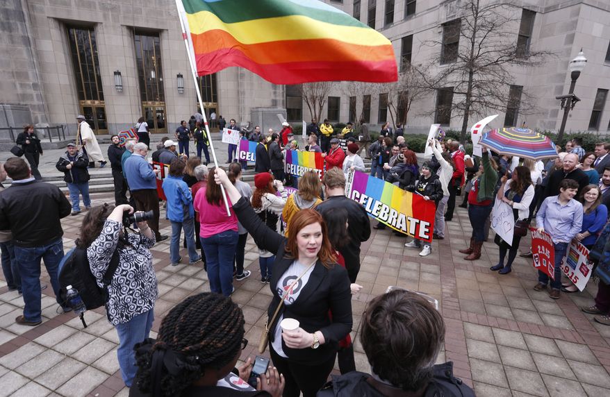 Amanda Keller holds a flag as she joins other gay marriage supporters in Linn Park at the Jefferson County courthouse Feb. 9 in Birmingham, Ala. Alabama began issuing marriage licenses to same-sex couples Monday after the U.S. Supreme Court refused to stop the marriages from beginning in the conservative southern state. (Associated Press)
