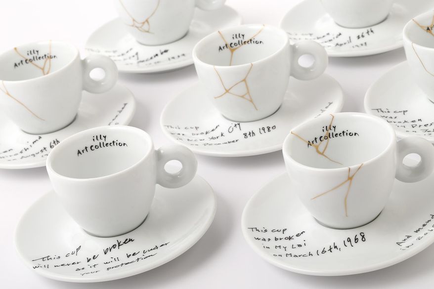 This image released by Illy North America shows a collection of espresso cups and saucers called, Yoko Ono: Mended Cups - illy Art Collection, featuring the dates and places of six tragic events written in Ono's handwriting. The collection is inspired by Kintsugi, the Japanese technique of repairing cracked pottery with brushstrokes of gold. The line for illy Art Collection is being released alongside Ono’s upcoming show at the Museum of Modern Art. (Lou Manna/Illy North America via AP)