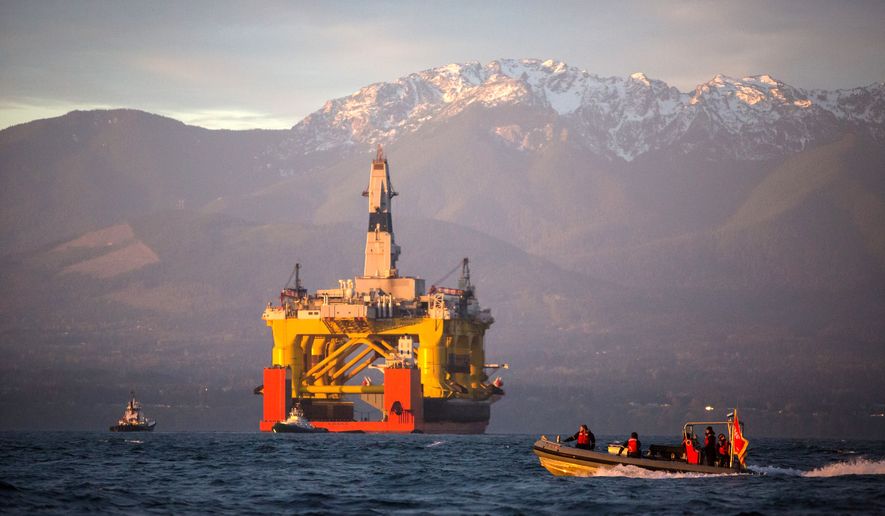 FILE - In this April 17, 2015, file photo, with the Olympic Mountains in the background, a small boat crosses in front of an oil drilling rig as it arrives in Port Angeles, Wash., aboard a transport ship after traveling across the Pacific. Royal Dutch Shell hopes to use the rig for exploratory drilling during the summer open-water season in the Chukchi Sea off Alaska's northwest coast, if it can get the permits. (Daniella Beccaria/seattlepi.com via AP, File) MAGS OUT; NO SALES; SEATTLE TIMES OUT; TV OUT; MANDATORY CREDIT