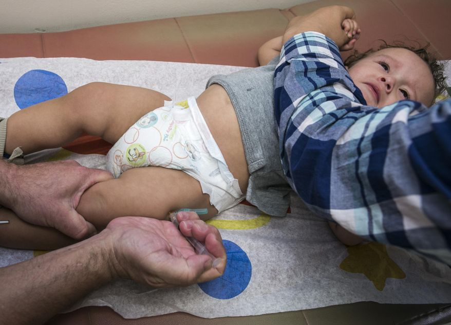 Pediatrician Charles Goodman vaccinates 1-year-old Cameron Fierro with the measles-mumps-rubella vaccine, or MMR vaccine, at his practice in Northridge, Calif., on Jan. 29, 2015. (Associated Press) **FILE**