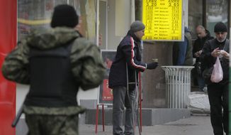 A man begs on a street near a currency exchange bureau in Kiev, Ukraine, Thursday, Nov. 13, 2014.  Ukraine&#39;s hryvnia plunged to UAH 15.56/USD on Nov. 13, a 14% decline since Nov. 5, when the National Bank of Ukraine reduced its interventions at the ForEx and allowed further weakening. Ukraine&#39;s national currency has already lost nearly 47% of its value this year, falling from UAH 8.1/USD.  (AP Photo/Efrem Lukatsky)