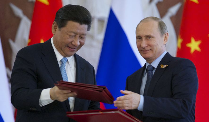 Russian President Vladimir Putin, right, and Chinese President Xi Jinping exchange documents at the signing ceremony in the Kremlin in Moscow, Friday, May 8, 2015. Russian and Chinese leaders have signed a plethora of deals in Moscow, giving Russia billions in infrastructure loans. (Associated Press) ** FILE **
