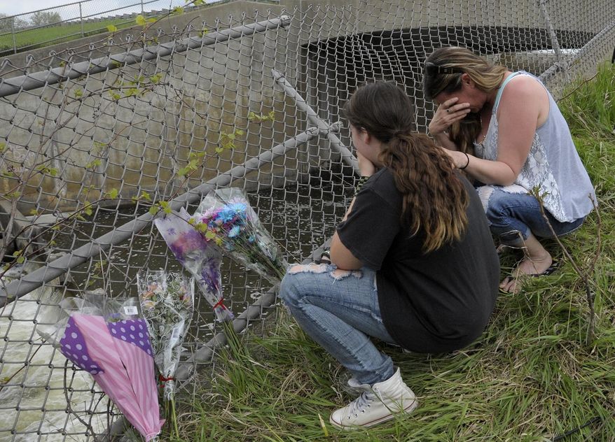 In this Saturday, May 9, 2015, photo, relatives of one of the three teenagers who died in a crash, Sherrie Logan, right, and her daughter, Allie Logan, 14, pay respects at the crash site in Shelby Township, Mich. The Macomb County sheriff's department says the teens were in a speeding Jaguar that landed in the Stony Creek River on Friday evening. The site is in Stoney Creek Metropark in Shelby Township, 35 miles north of Detroit. (Todd McInturf/Detroit News via AP) DETROIT FREE PRESS OUT; HUFFINGTON POST OUT