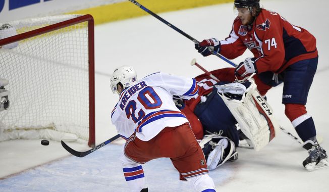 New York Rangers left wing Chris Kreider (20) scores his second goal of the period during the first period past Washington Capitals goalie Braden Holtby (70), center, and John Carlson (74) in Game 6 in the second round of the NHL Stanley Cup hockey playoffs, Sunday, May 10, 2015, in Washington. (AP Photo/Nick Wass)