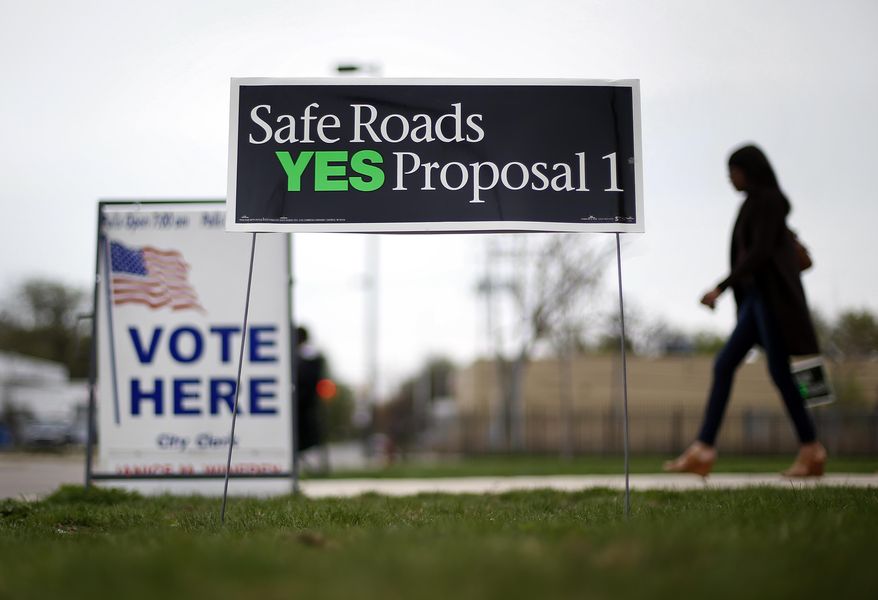 FILE - In this May 5, 2015 file photo, a voter leaves a polling location in Detroit. Voters sent a clear message to Gov. Rick Snyder and lawmakers after crushing a ballot measure that would have pumped $1.2 billion more a year into deteriorating roads and bridges: you must do better. Legislators are still processing how to proceed, but Proposal 1's defeat gave advocates of increased transportation spending some ideas of what not to do. (AP Photo/Paul Sancya)