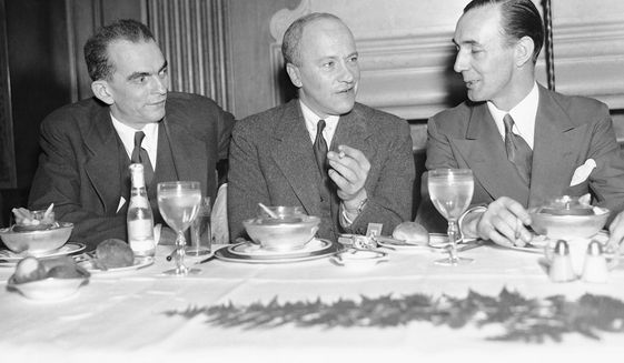Walter Duranty, New York Times correspondent, center, at a luncheon given in his honor by the Association of Foreign Press Correspondents at the Hotel Lombardy in New York, April 16, 1936.  At left is Kenneth Durant, representative of TASS, Soviet news agency, and at right is A. Bernard Moloney, of Reuters, president of the association. (AP Photo/John Rooney)