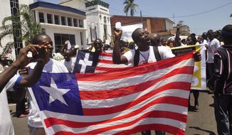 People display a representation of the Liberian flag as they celebrate Liberia being an Ebola free nation in Monrovia, Liberia, Monday, May 11, 2015. Liberians are gathering in the streets of the capital to celebrate the end of the Ebola epidemic in this West African country. Monday&#39;s festivities come after the World Health Organization declared over the weekend that Liberia was finally Ebola-free. (AP Photo/ Abbas Dulleh)