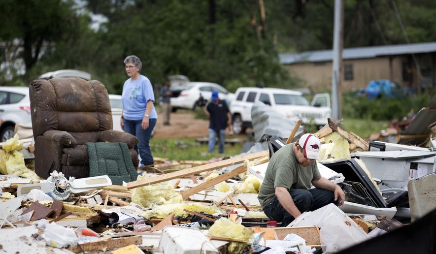 Ronnie Bevill sifts through the wreckage looking for anything salvageable from his aunts home Monday, May 11, 2015. A section of the D&J Mobile Home Park in Nashville, Ark., was destroyed after a EF2 tornado touched down late Sunday night. (Evan Lewis/The Texarkana Gazette via AP)