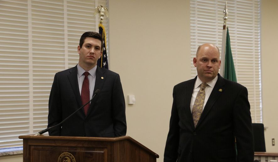 Reps. Drew Stokesbary, left, and Rep. Drew MacEwen, listen to a question at a press conference about their resolution seeking to impeach state Auditor Troy Kelley, Tuesday, May 12, 2015, in Olympia, Wash. Kelley is currently on unpaid leave after pleading not guilty in federal court to 10 felony counts, including allegations that he failed to pay taxes. (AP Photo/Rachel La Corte)