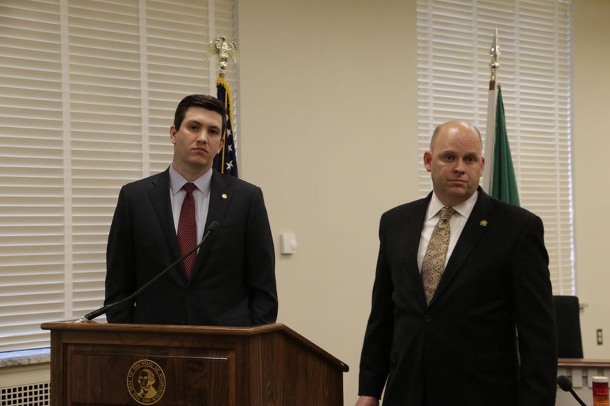 Reps. Drew Stokesbary, left, and Rep. Drew MacEwen, listen to a question at a press conference about their resolution seeking to impeach state Auditor Troy Kelley, Tuesday, May 12, 2015, in Olympia, Wash. Kelley is currently on unpaid leave after pleading not guilty in federal court to 10 felony counts, including allegations that he failed to pay taxes. (AP Photo/Rachel La Corte)