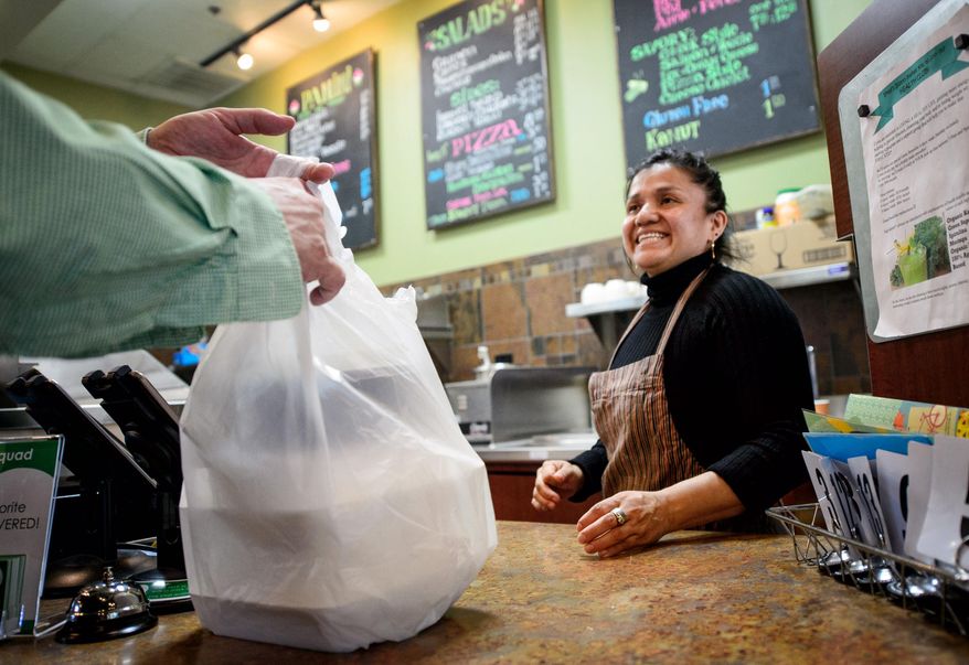 Sandra Mejia hands a carry-out food order to a customer at Vitali's Bistro on Monday, May 11, 2015 in St. Louis Park, Minn. (Glen Stubbe/Star Tribune via AP) MANDATORY CREDIT; ST. PAUL PIONEER PRESS OUT; MAGS OUT; TWIN CITIES LOCAL TELEVISION OUT