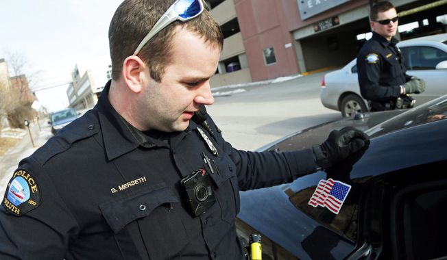 Duluth police officer Dan Merseth, (left) wears a body camera on the front of his uniform during his shift in Duluth, Minnesota. Outfitting cops with body cameras puts police departments in the precarious position of having to decide whether their officers need to keep their cameras on all the time or use them at their discretion, said New Mexico attorney Tom Grover. (Associated Press photographs)
