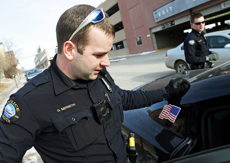 Duluth police officer Dan Merseth, (left) wears a body camera on the front of his uniform during his shift in Duluth, Minnesota. Outfitting cops with body cameras puts police departments in the precarious position of having to decide whether their officers need to keep their cameras on all the time or use them at their discretion, said New Mexico attorney Tom Grover. (Associated Press photographs)
