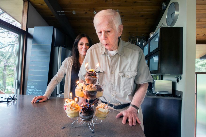 In this Monday April 27, 2015 photo provided by West Virginia University, 94-year-old Anthony Brutto blows out the candles on a birthday cake as his daughter, Lisa Bridges, looks on in his home in Morgantown, W. Va. Brutto will be one of the oldest graduates in the history of West Virginia University when he receives his diploma Sunday, May 17. (Brian Persinger/West Virginia University via AP)