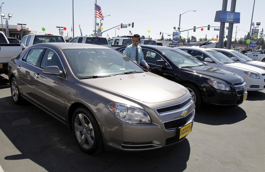 FILE - In this Aug. 30, 2011 file photo, 2011 Chevrolet Malibus are lined up at a car dealership in San Jose, Calif. General Motors is recalling nearly 470,000 Chevrolet Malibu midsize cars from the 2011 and 2012 model years to fix potentially weakened steel cables that link the front seat belts to the vehicles. (AP Photo/Paul Sakuma, File)