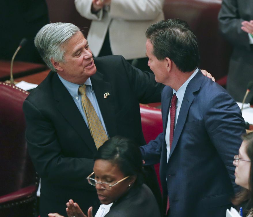Former Senate Majority Leader Dean Skelos, R-Rockville Centre, left, congratulates new Senate Majority Leader John Flanagan, R-Smithtown, after his election in the Senate Chamber at the Capitol on Monday, May 11, 2015, in Albany, N.Y. Skelos resigned his position as the leader following his arrest on federal corruption charges. (AP Photo/Mike Groll)