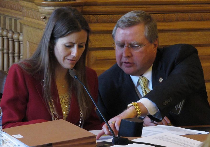 Kansas state Reps. Kasha Kelley, left, an Arkansas City Republican, and Mark Hutton, right, a Wichita Republican, confer over a tax proposal during a House committee meeting, Tuesday, May 12, 2015, at the Statehouse in Topeka, Kan. Hutton supports efforts to roll back an income tax break granted in 2012 to business owners and farmers, while Kelley opposes them. (AP Photo/John Hanna)