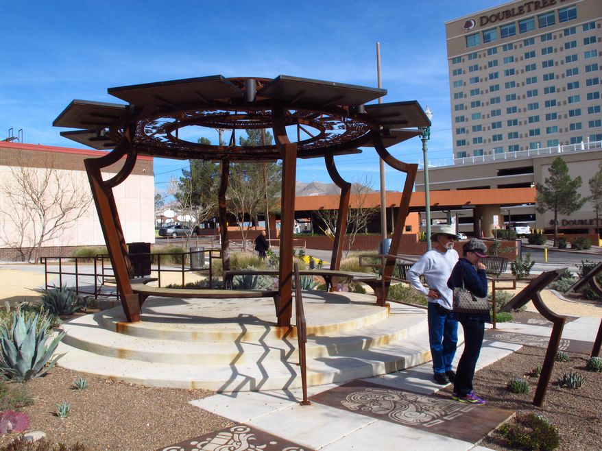 ADVANCE FOR SUNDAY MAY 17 AND THEREAFTER - Downtown El Paso pedestrians can charge their electronic devices for free using 12 solar-powered outlets beneath benches in the Aztec Calendar Pavilion in the city's arts district. The charging station is one of numerous ways El Paso officials are making the city more green. (AP Photo/Betsy Blaney)