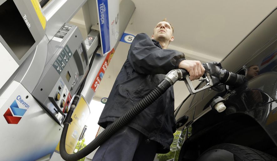 In this May 6, 2015 photo, attendant James Lewis pumps gas at a station in Portland, Ore. Even after the typical springtime run-up, the average price for gallon of regular gasoline should top out around $2.60, experts say. (AP Photo/Don Ryan)