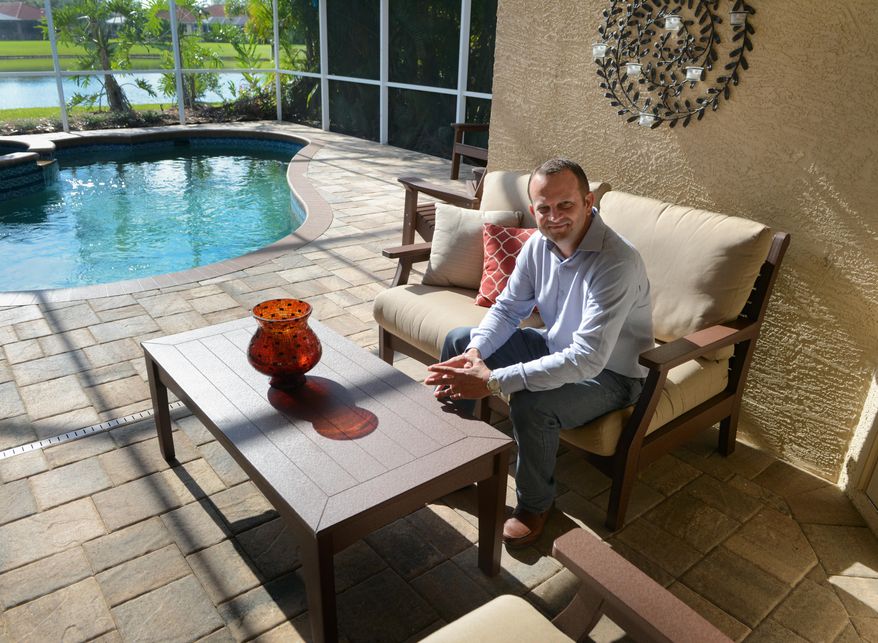 ADVANCE FOR USE SATURDAY, MAY 16, 2015, AND THEREAFTER- In this May 4, 2015 photo, Jim Miller poses for a photo with a Berlin Gardens couch and coffee table at his home in Sarasota, Fla. Jim Miller, a former Mennonite pastor in Sarasota, and his wife have become one of the largest Internet-only marketers of Amish-made furniture. (Dan Wagner/Sarasota Herald-Tribune via AP) PORT CHARLOTTE OUT; BRADENTON HERALD OUT; TV OUT; ONLINE OUT