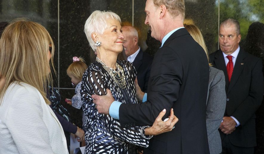 Joan "Jody" Dixon, the wife of former U.S. Sen. Alan J. Dixon, greets her son Jeffrey Dixon, after he spoke at a dedication ceremony to name the building that houses the Illinois State Museum after his father, Wednesday, May 13, 2015 in Springfield, Ill. The building is now called the Alan J. Dixon Building. During the ceremony, House Speaker Michael Madigan said Dixon "was just about helping people, helping working people get ahead." (Ted Schurter/The State Journal Register via AP) MANDATORY CREDIT, NO SALES
